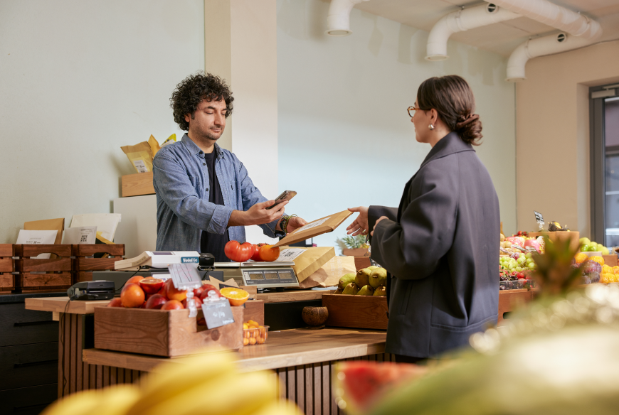 A shop's personal giving a parcel to a recipient